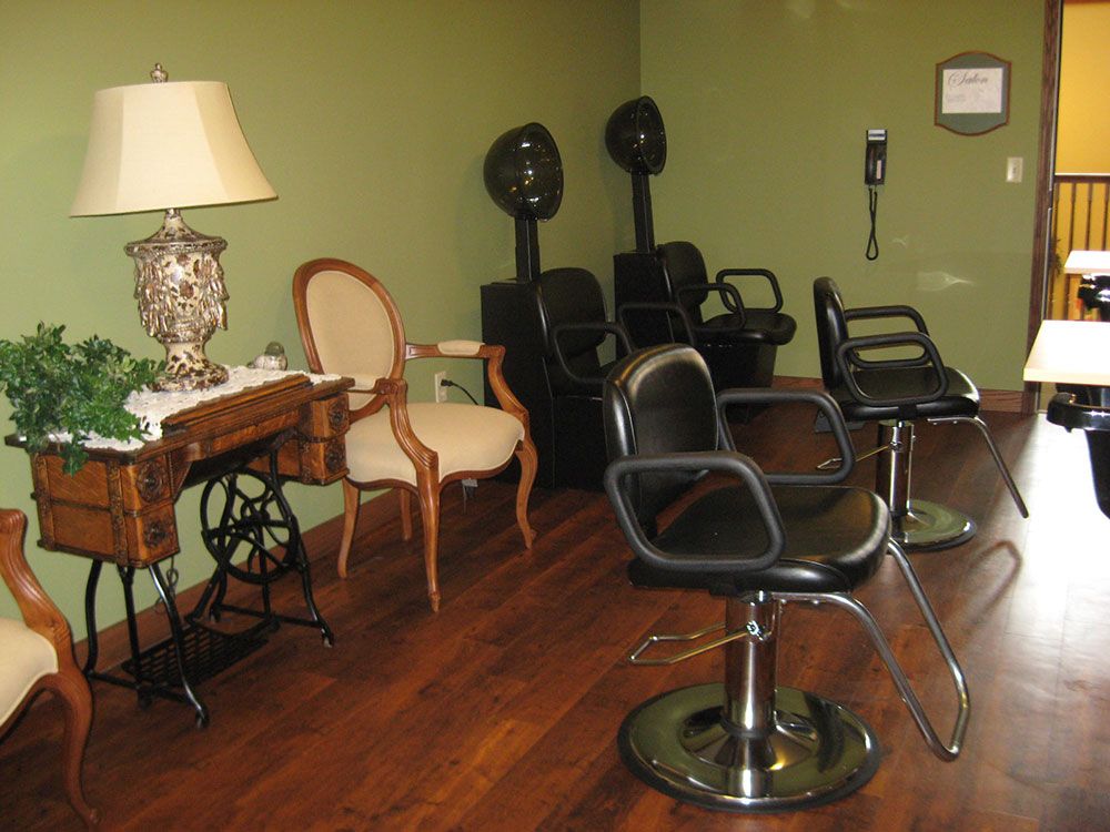 A cozy hair salon interior featuring styling chairs, vintage decor, and hair dryers.