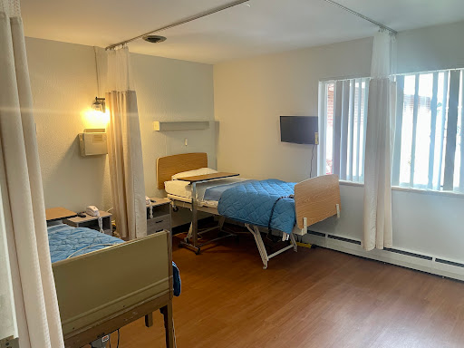 A well-lit hospital room featuring two patient beds, designed for comfort and care.