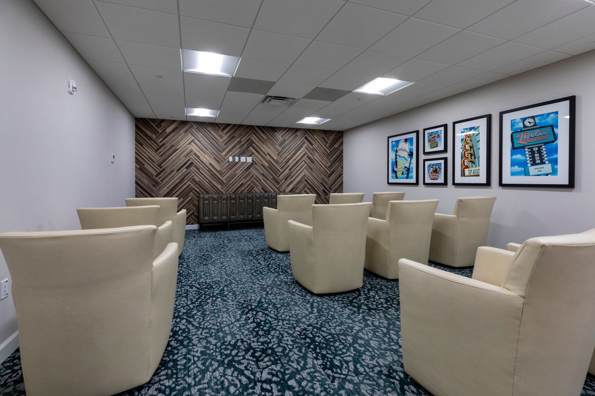 A modern waiting room with comfortable armchairs and artwork on the walls.