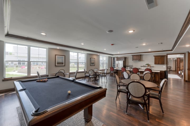 A spacious game room featuring a pool table and seating area.
