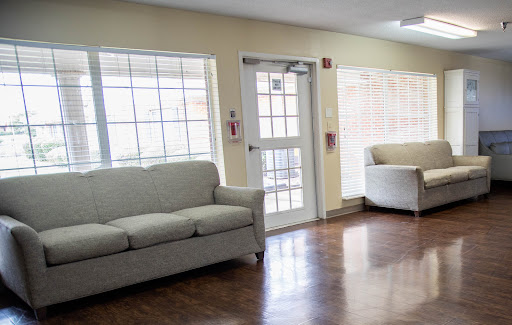 A cozy seating area in a well-lit lobby, featuring a soft sofa and armchair.