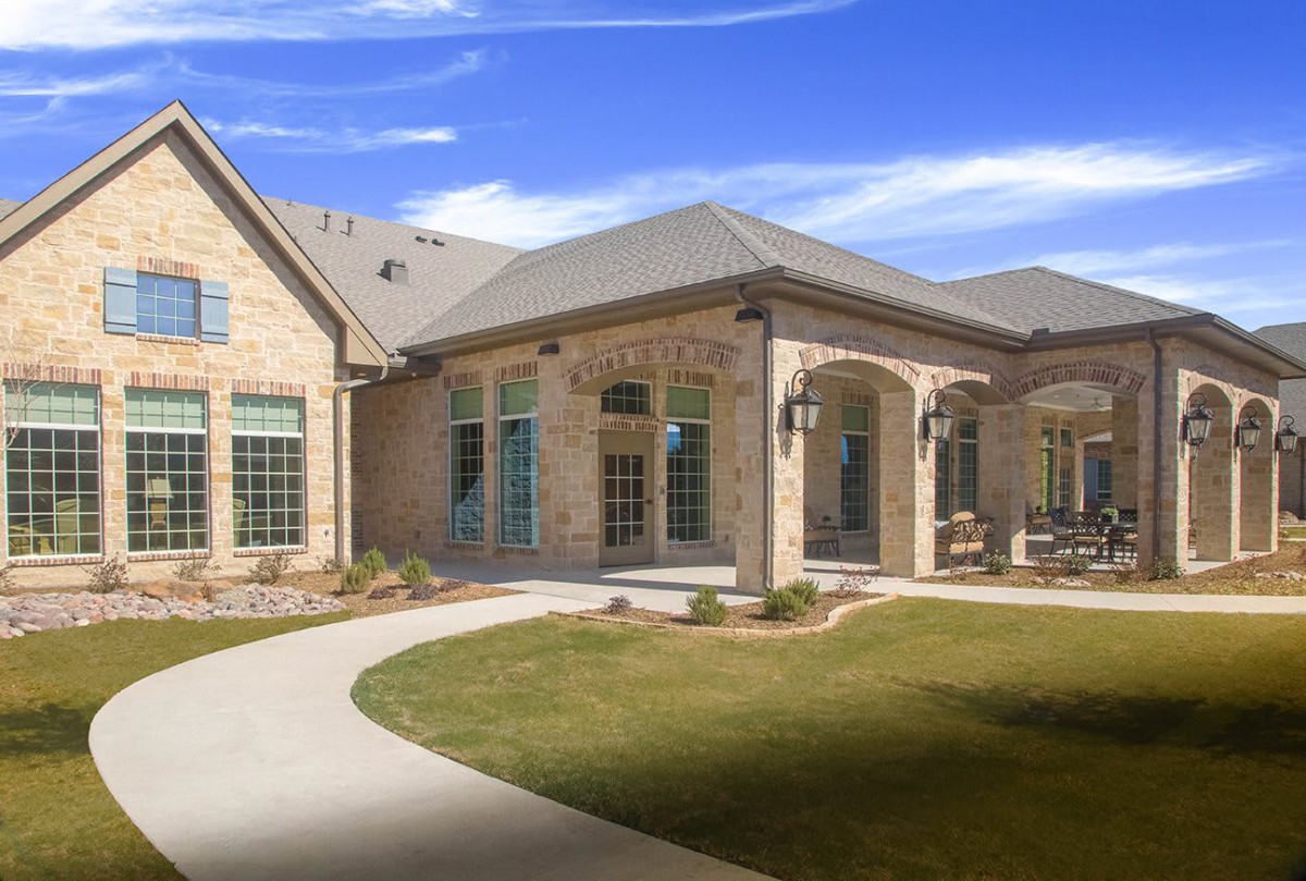 A modern brick house with a well-maintained lawn and pathway.