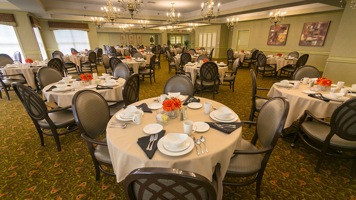 An elegant dining room with tables set for a formal meal.