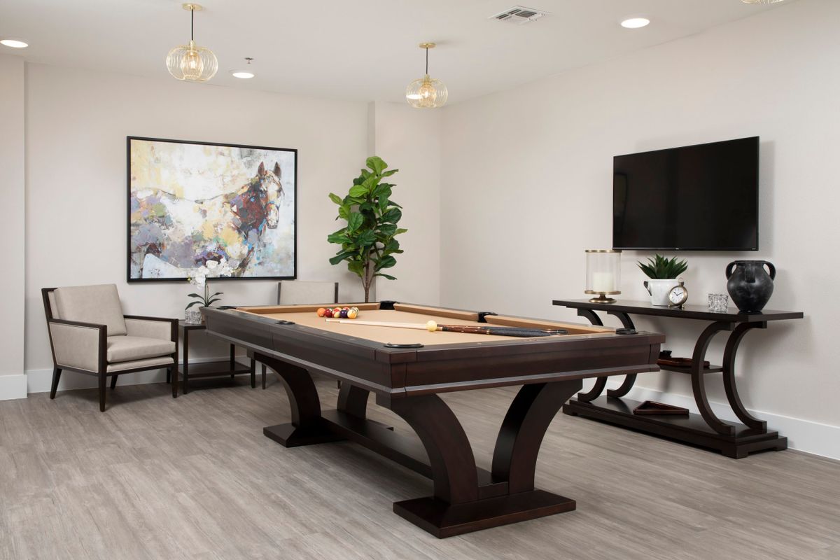 A modern game room featuring a stylish pool table, contemporary artwork, and sleek interior design elements.