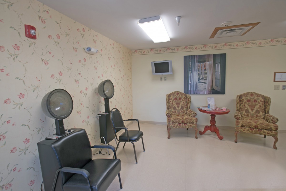 A cozy hair salon waiting area with hair dryers and seating.