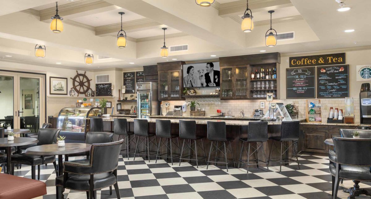 A modern cafe with checkered flooring and a sleek bar area.