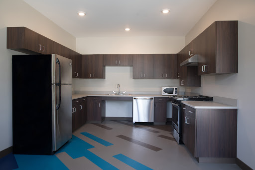 A modern kitchen featuring sleek cabinetry, stainless steel appliances, and a unique floor design.