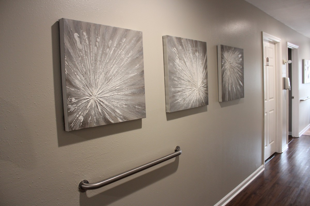 Abstract monochrome paintings displayed in a hallway.