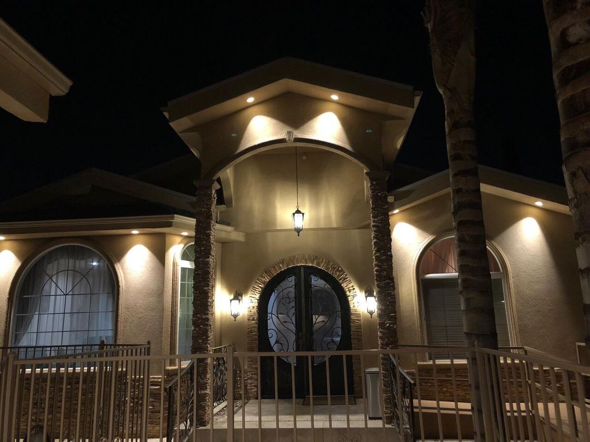 A well-lit house exterior at night, showcasing its architectural design.