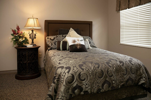 A cozy and elegantly decorated bedroom featuring a stylish bed with intricate bedding and a bedside lamp.