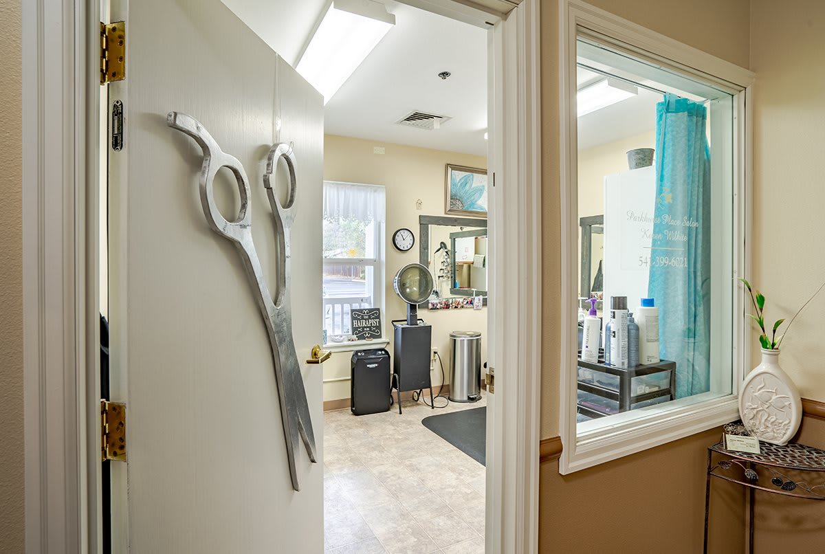 A cozy hair salon interior with scissors wall decor and various salon equipment.