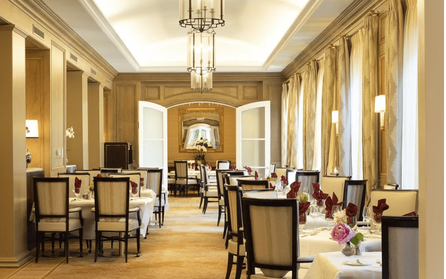 An elegant and luxurious dining room with beautifully set tables and chandeliers.