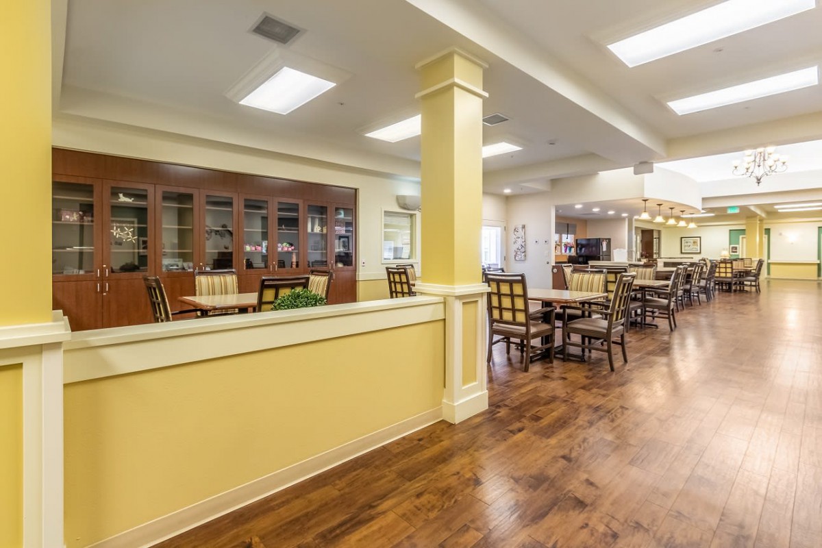 A spacious dining area featuring wood flooring and comfortable seating arrangements.
