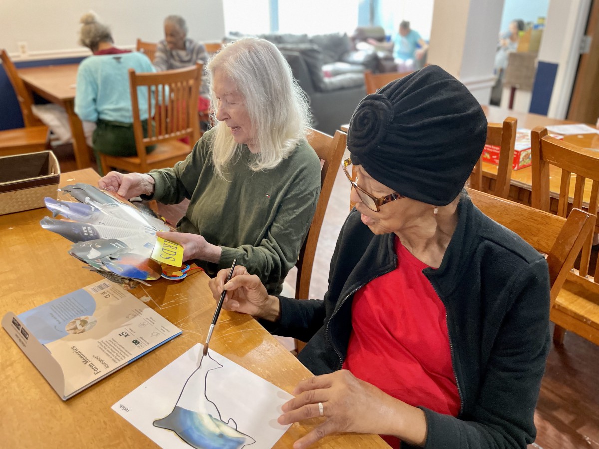 Seniors engaged in an art class, painting and enjoying community activities.
