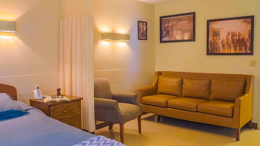 A cozy living space featuring a brown sofa, a comfortable chair, and subtle wall lighting.