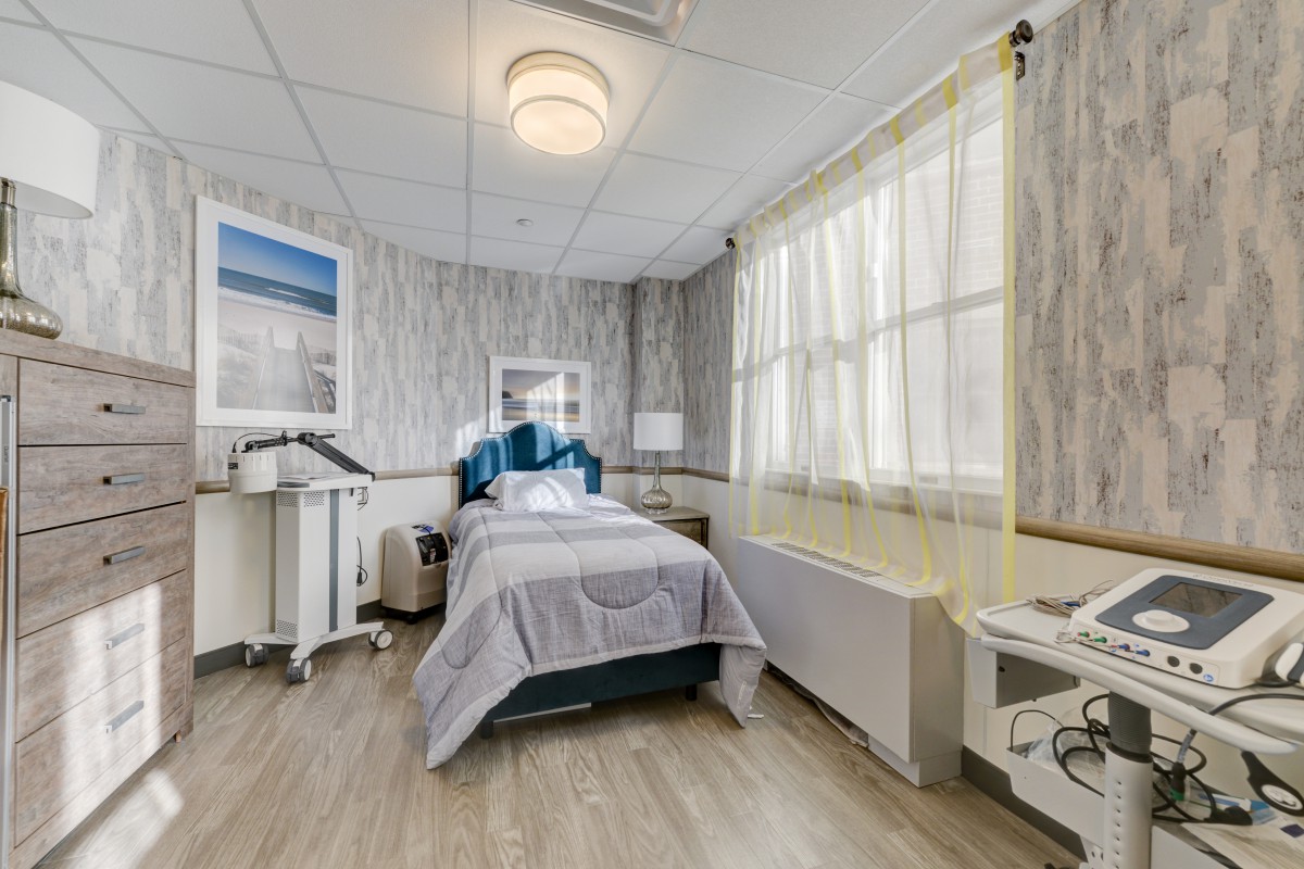 A clean and tidy hospital room with a bed and medical equipment.