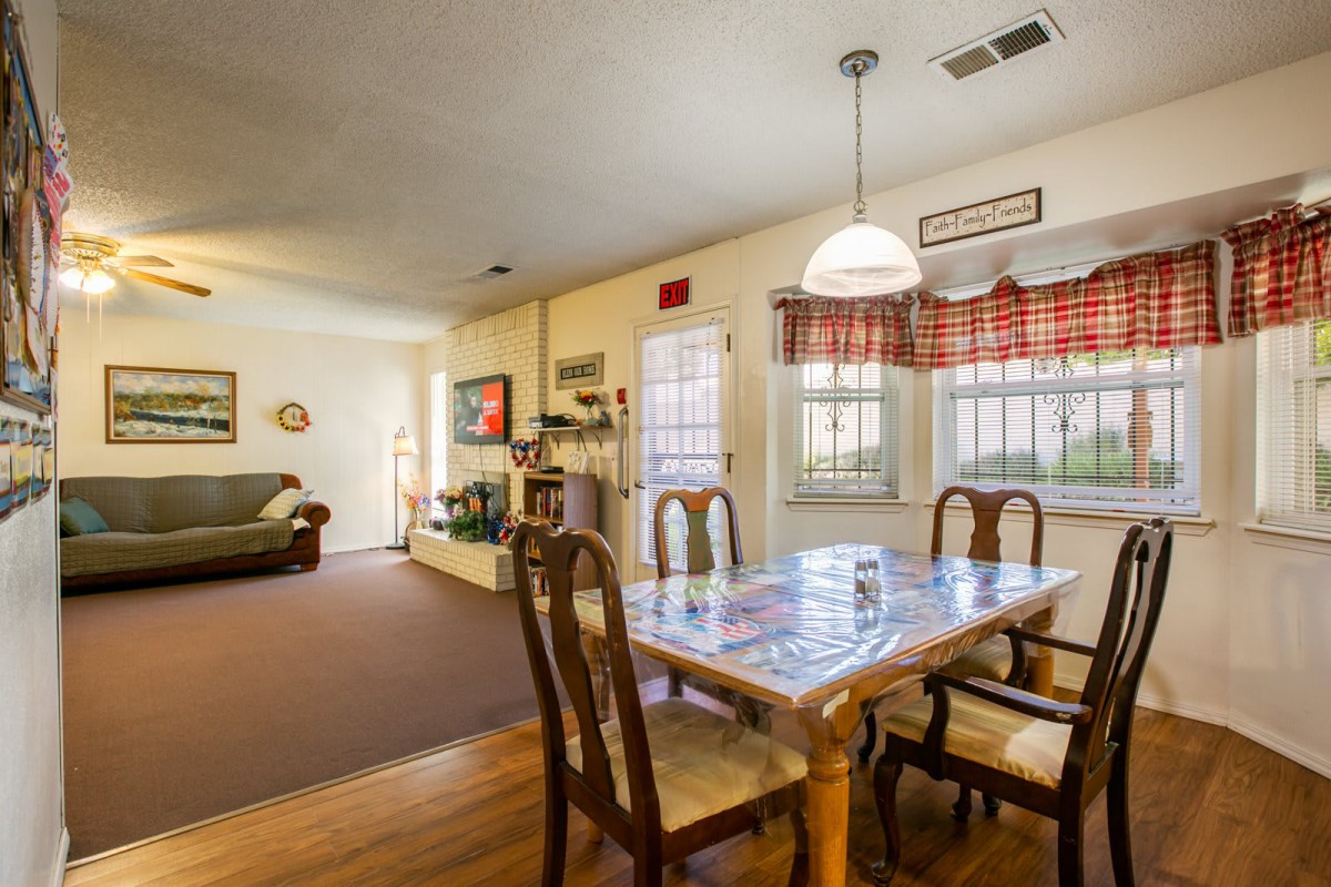 A cozy dining area connected to a living room, featuring a wooden table and chairs.