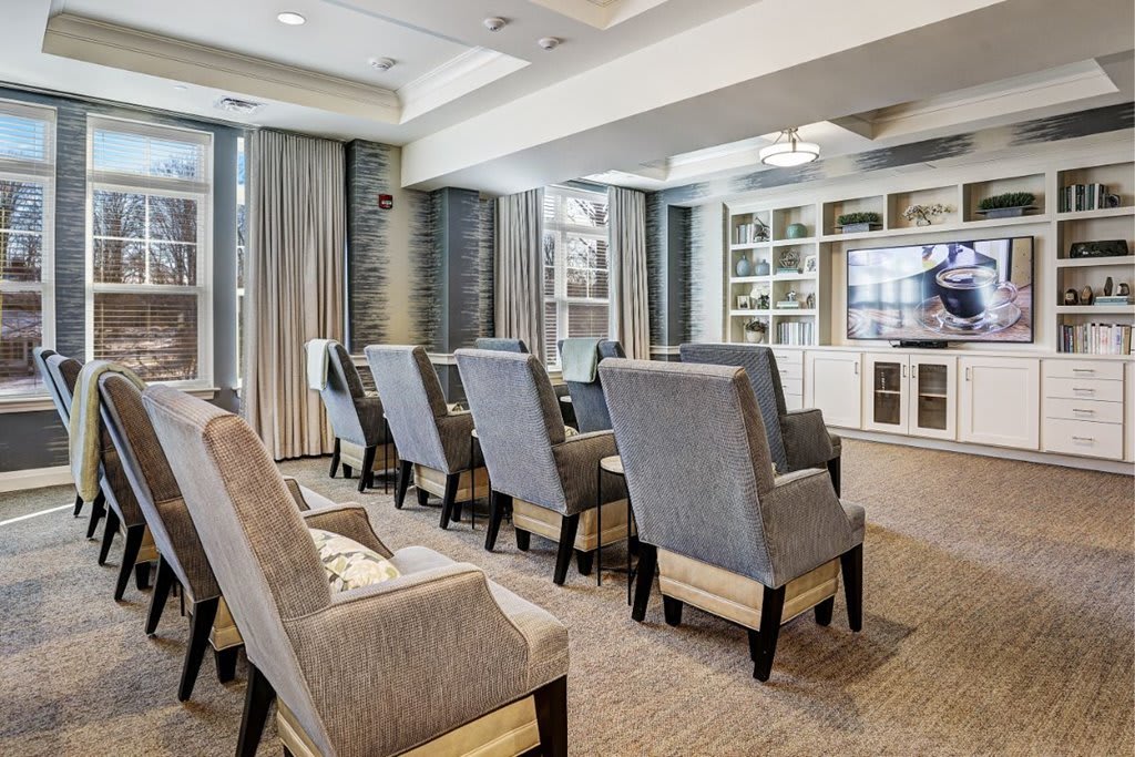 A modern home theater room with comfortable seating and a large television.