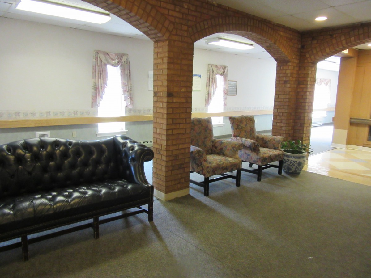 A cozy waiting area with comfortable seating and brick archways.
