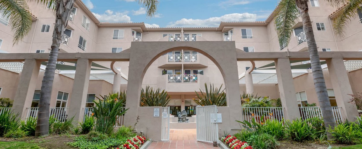 A residential building entrance with an archway and landscaped garden.