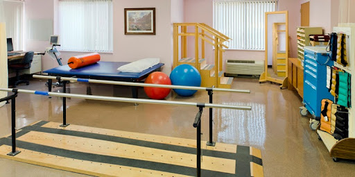A well-equipped physical therapy room featuring exercise balls, therapy bars, and rehabilitation tools.