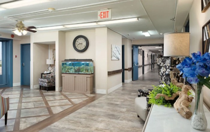 A well-lit hallway featuring an aquarium and a clock on the wall.