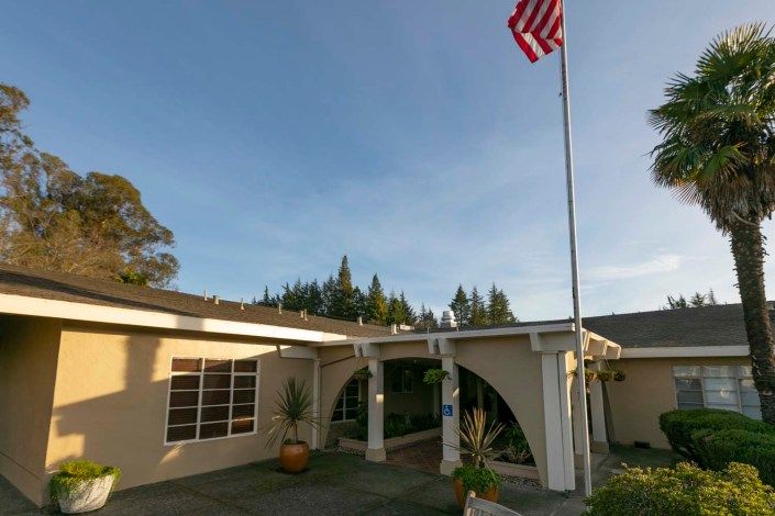 A building entrance with an American flag displayed on a flagpole.