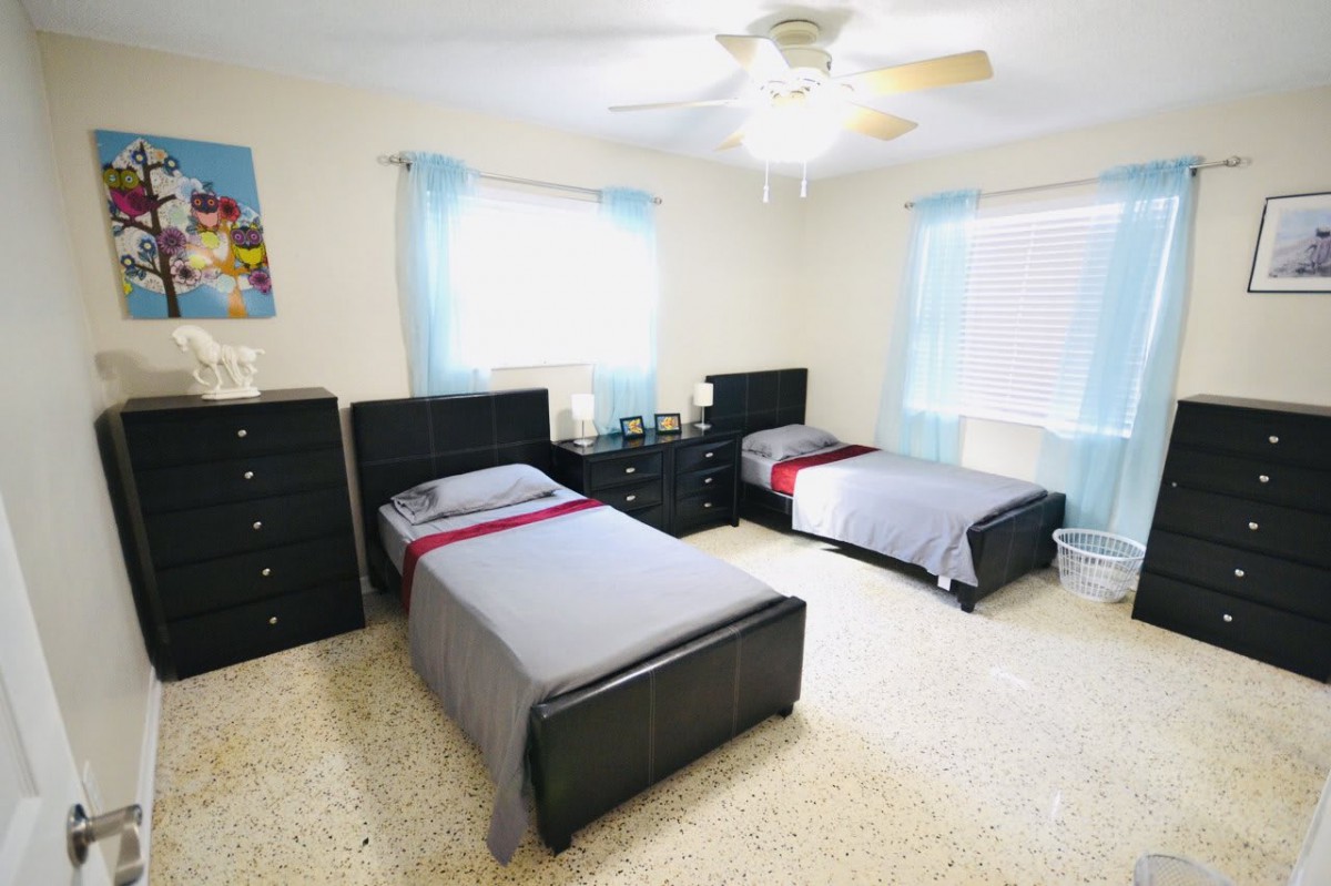 A bright bedroom with two twin beds and minimalist decor.