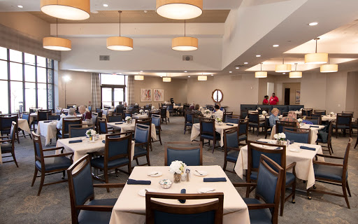 A spacious and inviting dining area featuring neatly arranged tables and warm lighting.
