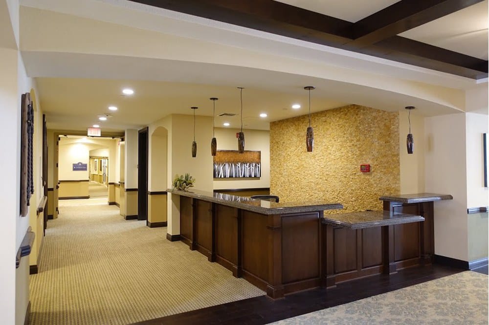 A modern lobby with a reception counter and warm lighting.
