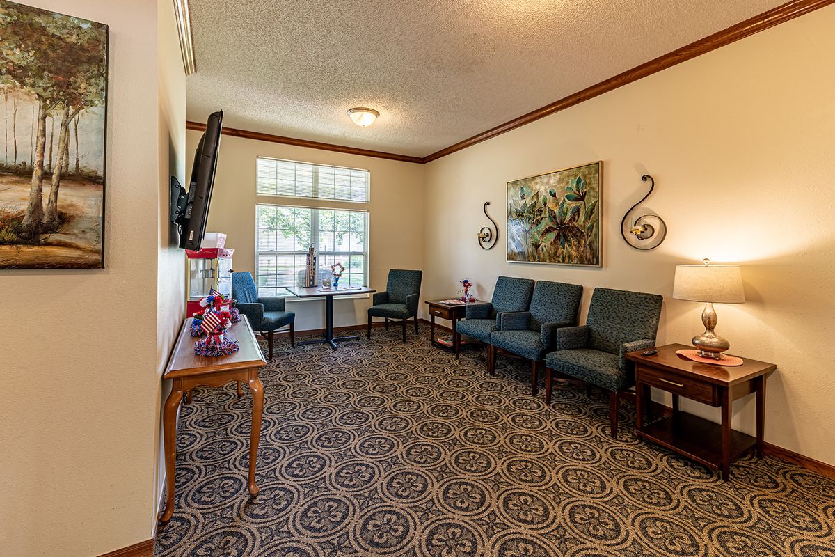 A cozy waiting room with several chairs, a small table, and decorative wall art.