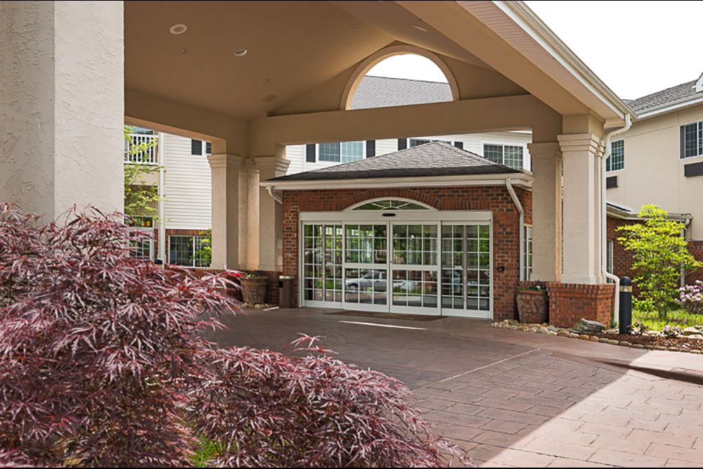 Entrance of a modern building with a landscaped driveway.