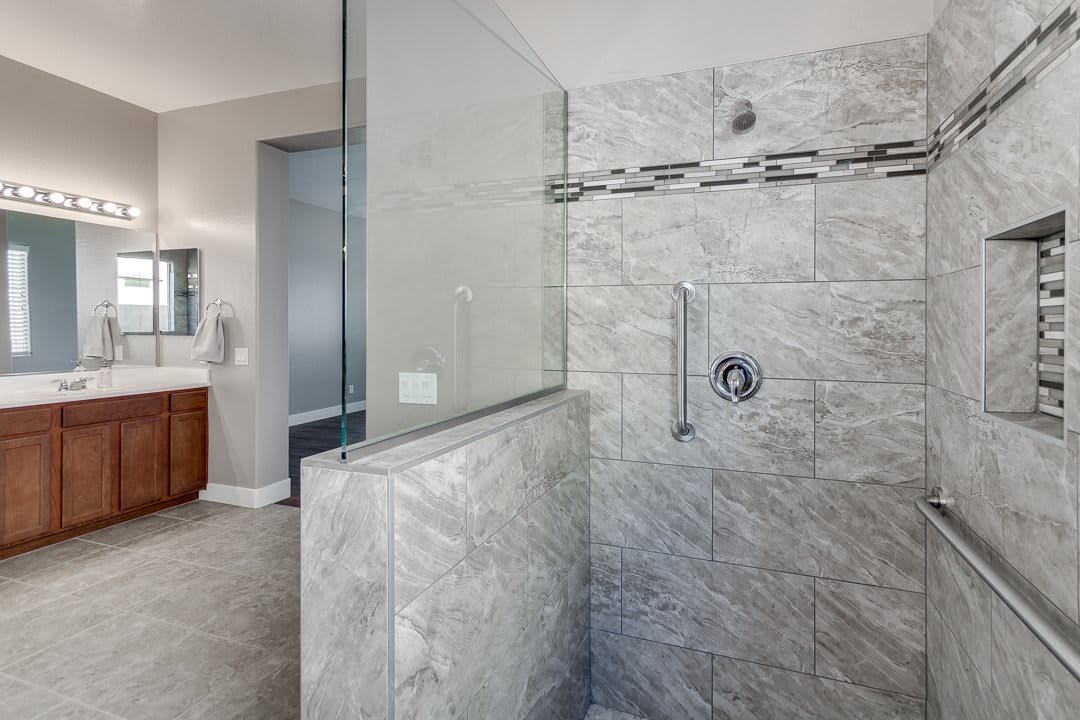 A modern bathroom featuring a glass-enclosed shower with tiled walls.