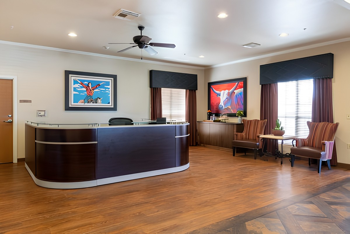 A modern reception area with a desk, artwork on the walls, and comfortable seating.