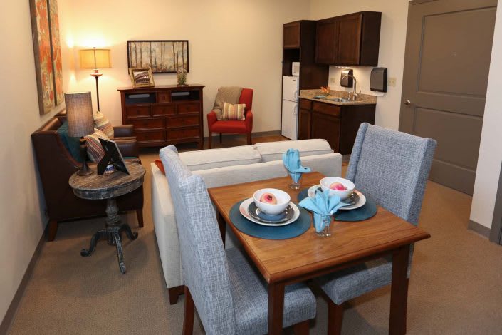 A cozy apartment featuring a compact living room with a dining area and kitchenette.