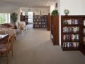A cozy library interior with wooden bookshelves and comfortable seating.