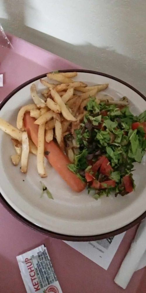 A plate with fries, a carrot, and a side of salad.