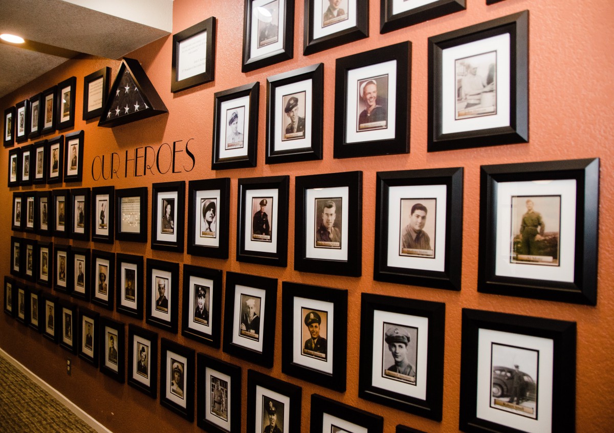 A wall display featuring framed photographs of veterans as a tribute.