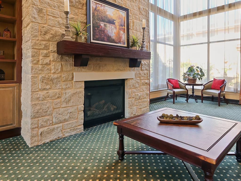 A cozy living room with a stone fireplace and large windows.