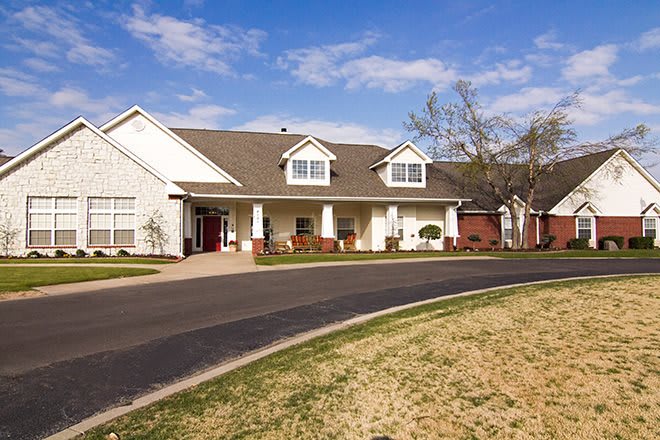 A residential house with a spacious driveway under a clear blue sky.