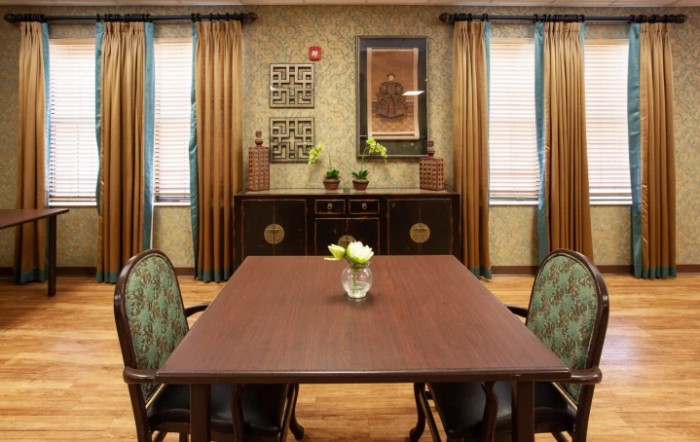 A traditional dining room with a wooden table, chairs, and decorative elements.