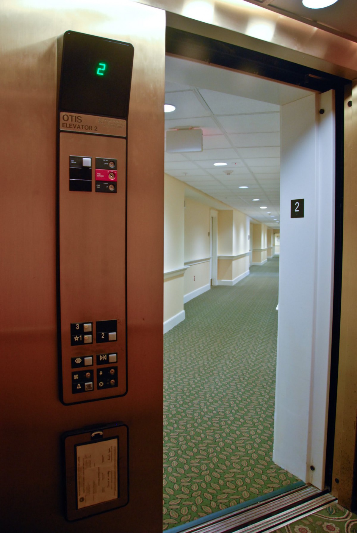 The image shows an open elevator door revealing a carpeted hallway on the third floor.