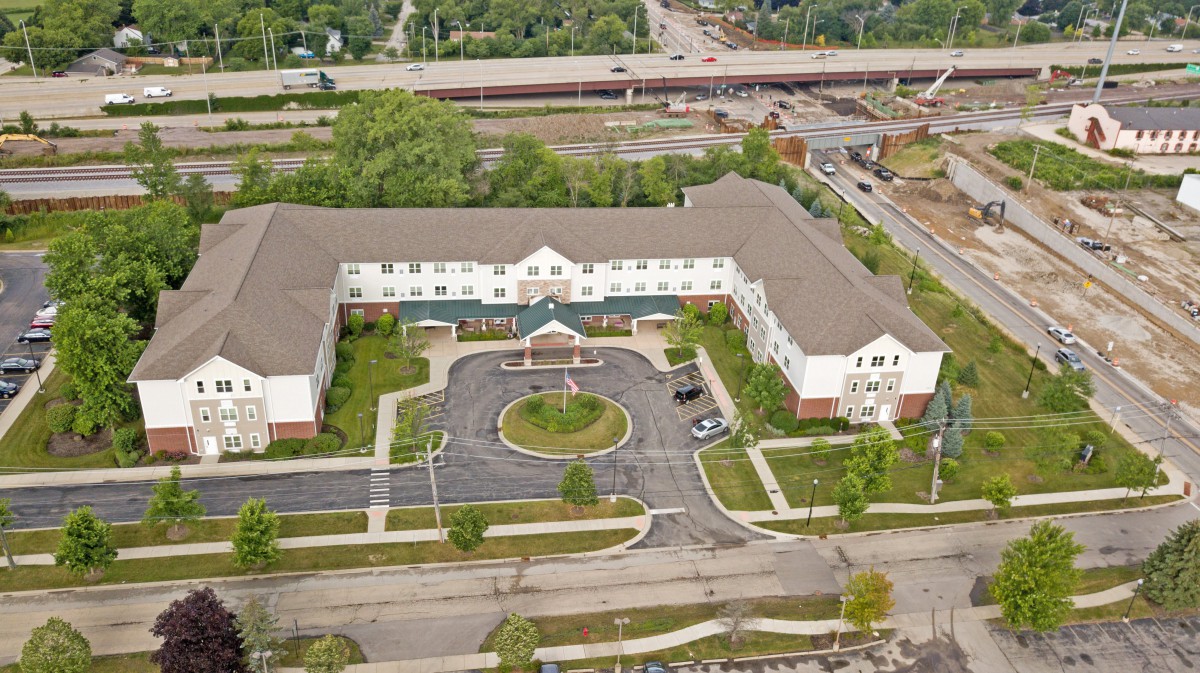Aerial view of a U-shaped building with surrounding roads and greenery.