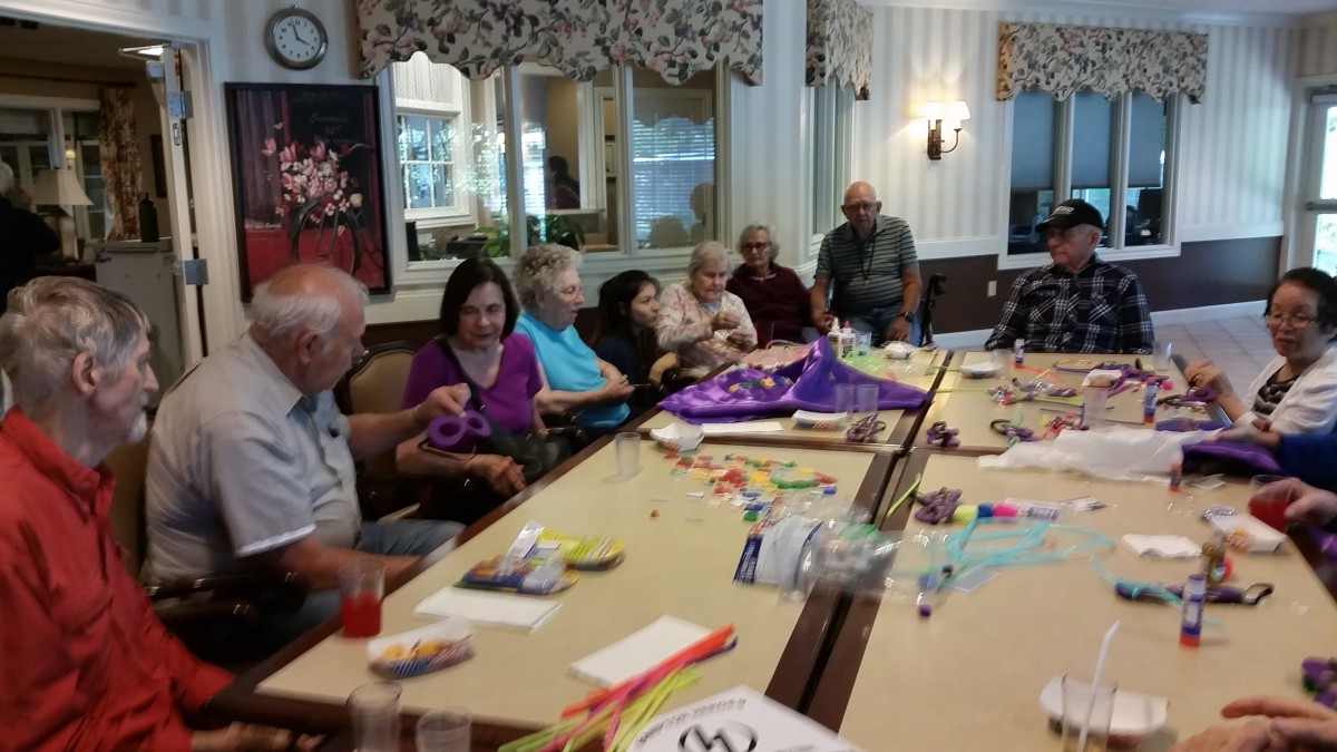 A group of people engaging in a craft activity together, surrounded by various art supplies.