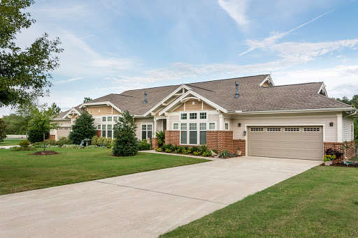 A charming suburban home with a spacious driveway and well-maintained landscaping.