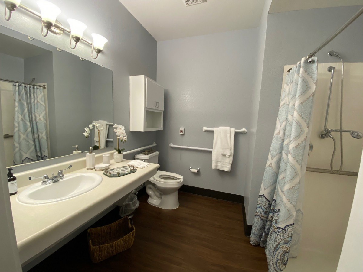 A neatly organized bathroom featuring a sink, toilet, and shower area.