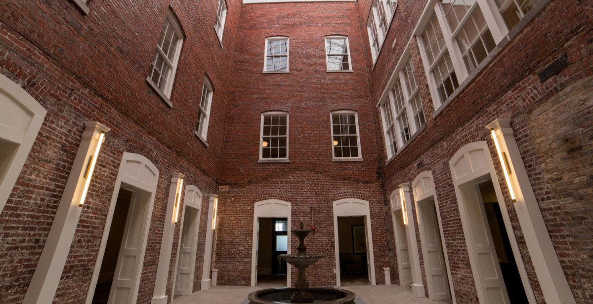 An indoor courtyard with brick walls and a central fountain.
