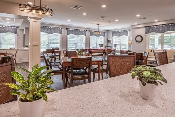A spacious dining area with wooden furniture, large windows, and modern lighting.