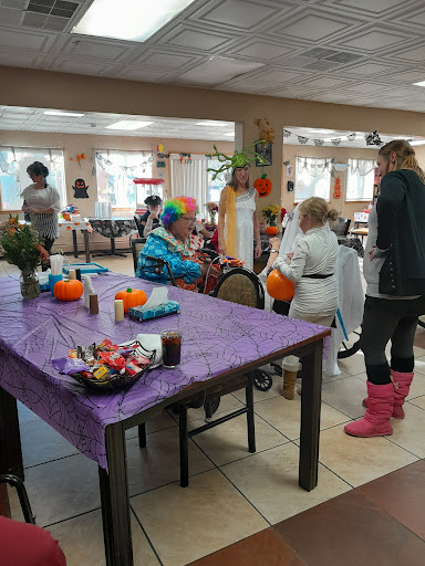 A festive gathering at a community center with decorations and activities, featuring a clown entertaining attendees.