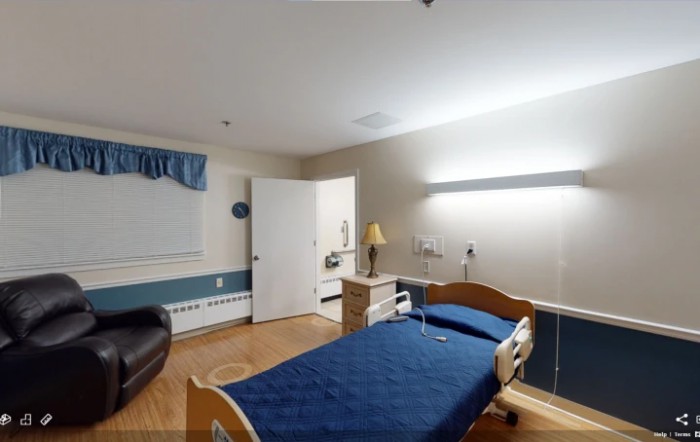 A hospital room with a single patient bed and essential furnishings.